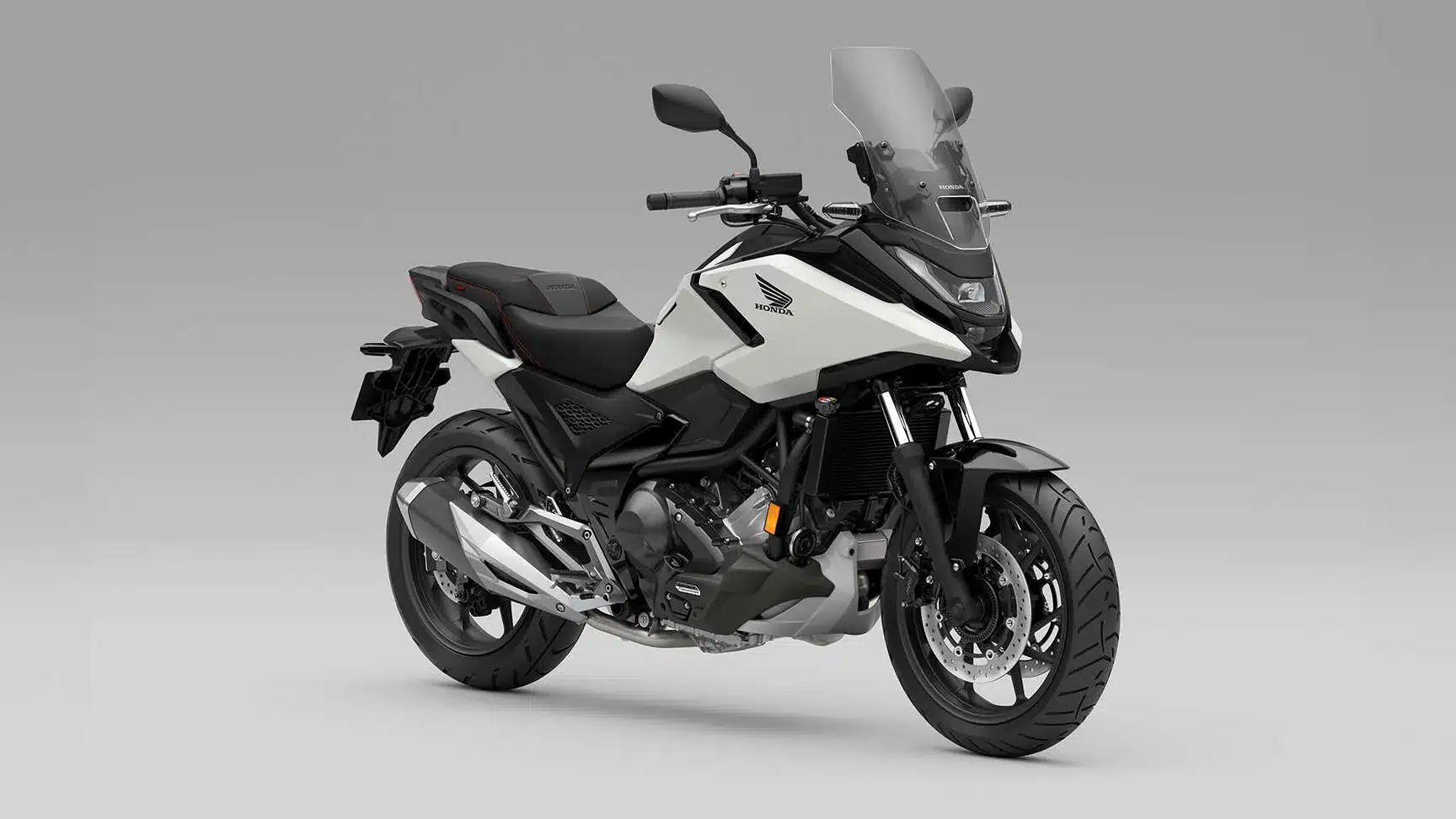 Honda NC750X Motorrad, seitlich fotografiert, weiß-schwarzes Modell mit Windschild und moderner Verkleidung.