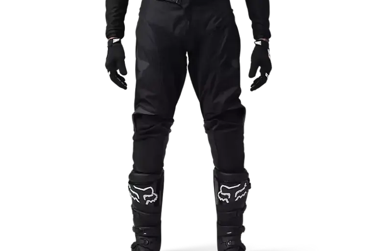 Motocross-Fahrer in schwarzer FOX 180 Blackout Crosshose mit Schutzstiefeln und Handschuhen.
