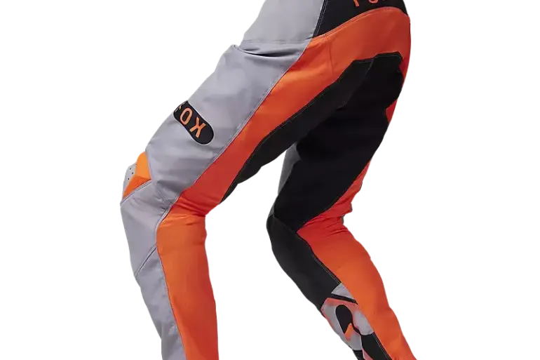 FOX 180 Emotion Crosshose in orange-grauer Farbkombination mit schwarzen Akzenten, seitliche Ansicht.