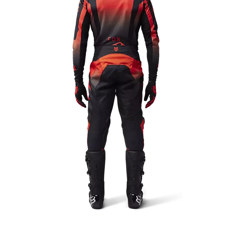 Rückansicht einer Motocross-Fahrerausrüstung mit der Fox 180 Lean Hose in Rot und Schwarz, getragen von einer Person in kompletter Motorradbekleidung.