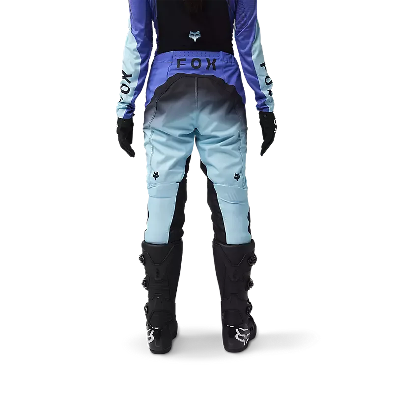Rückansicht einer Frau in der blauen Flexair Infinite MX-Hose mit Schutzstiefeln und Handschuhen.