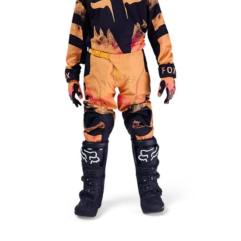 Jugendlicher in Motocross-Ausrüstung mit 180 Kairos Hose in Orange und Schwarz, Schutzstiefeln und Handschuhen