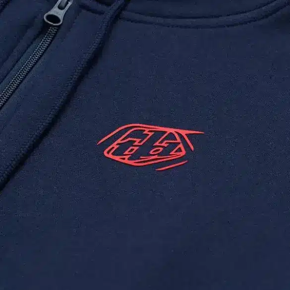 Marineblauer Kapuzenpulli mit rotem Markenzeichen und Reißverschluss im Detail