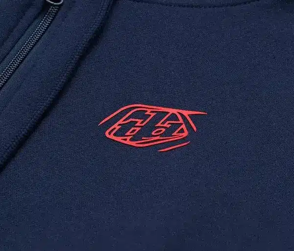 Marineblauer Kapuzenpulli mit rotem Markenzeichen und Reißverschluss im Detail