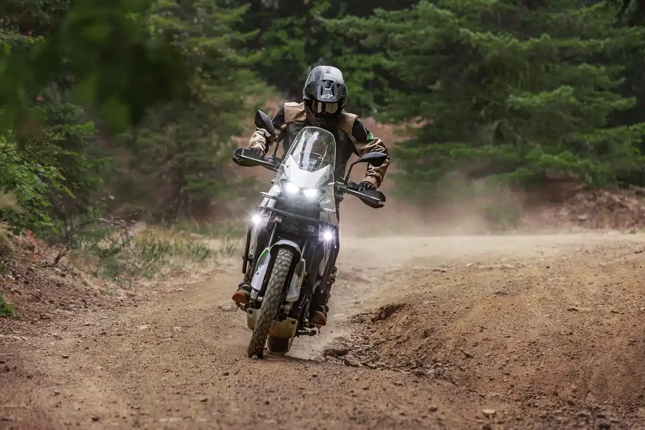 Kawasaki KLE500 SE 2026 fährt durch eine staubige Waldpiste im Gelände