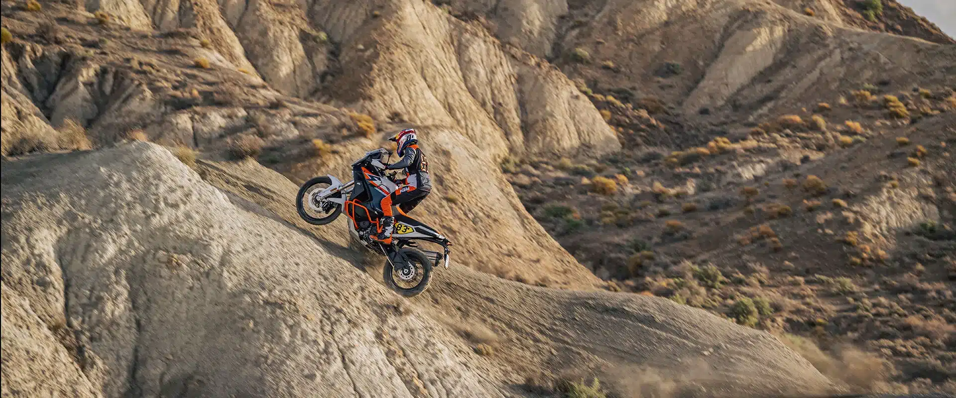 KTM 1390 Super Adventure R fährt steile Schotterpiste in felsiger Landschaft hoch