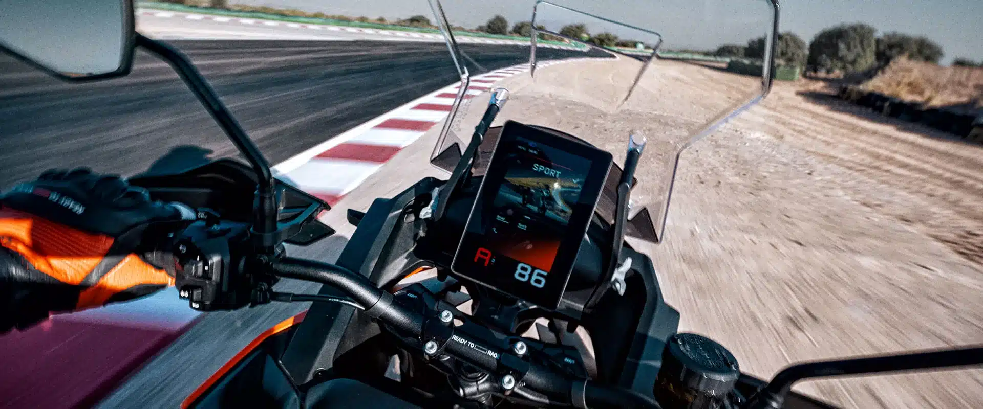 Blick auf das digitale Cockpit und den Lenker einer KTM 1390 Super Adventure S EVO während der Fahrt.