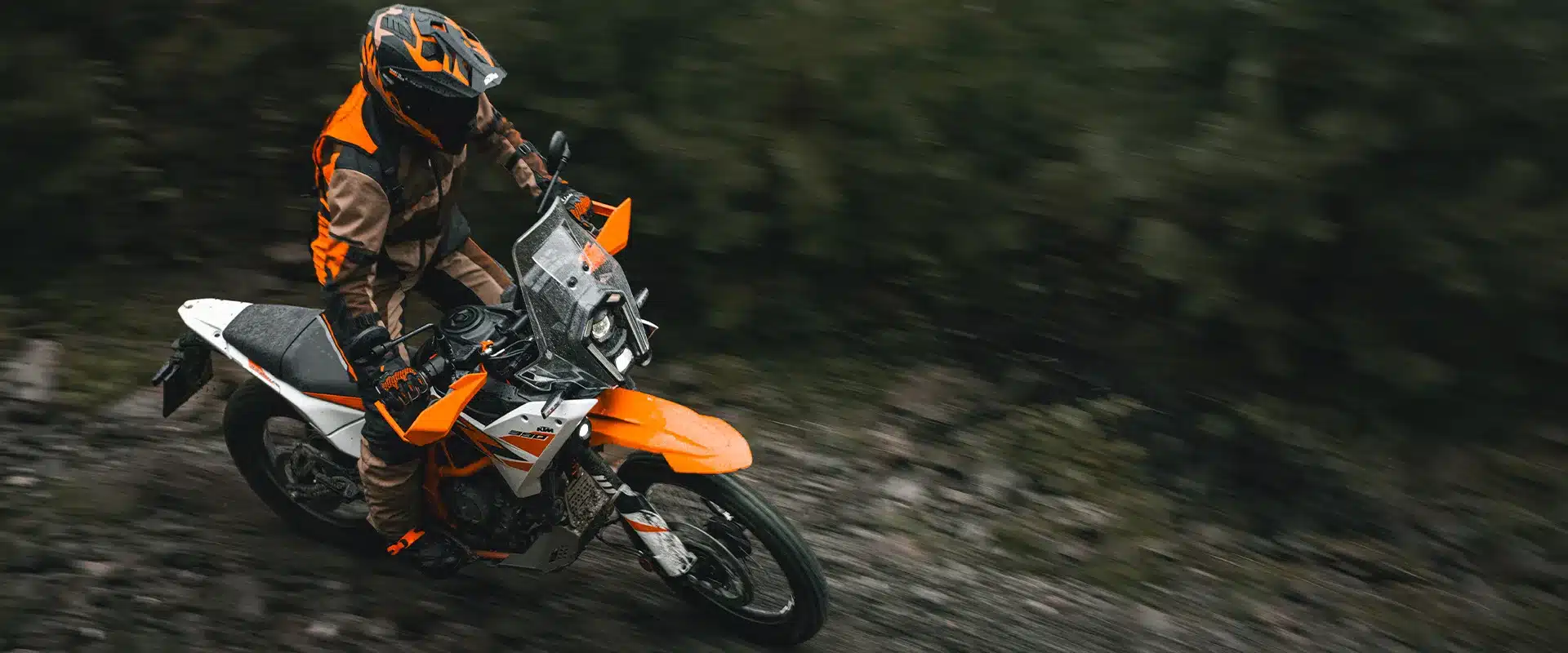 KTM 390 Adventure R 2026 fährt auf Schotterweg im Gelände, Motorradfahrer in voller Offroad-Ausrüstung.