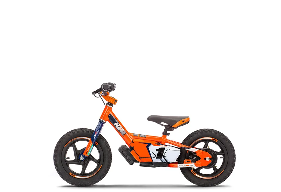 KTM SX-E 1.12 Elektro-Laufrad für Kinder in Orange – Seitenansicht vor weißem Hintergrund.