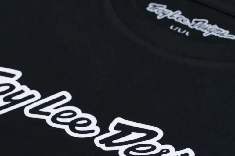Nahaufnahme vom Troy Lee Designs Kurzarm-T-Shirt Signature Black mit weißem Logo-Schriftzug.
