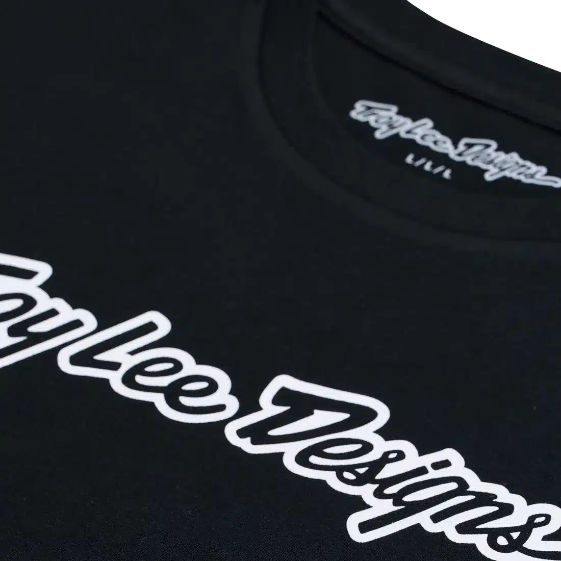 Nahaufnahme vom Troy Lee Designs Kurzarm-T-Shirt Signature Black mit weißem Logo-Schriftzug.