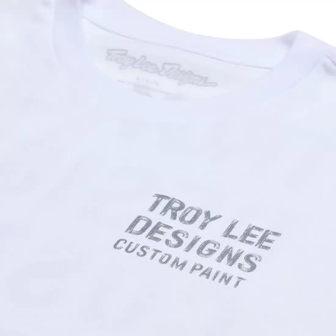 Weißes T-Shirt von Troy Lee Designs mit grauem Schriftzug Custom Paint auf der Brust.