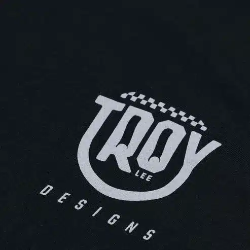 Schwarzes T-Shirt mit aufgedrucktem Smiley-Logo und Troy Lee Designs Schriftzug.