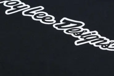 Detailaufnahme vom Troy Lee Designs Signature Langarm-T-Shirt Schwarz mit weißem Logoaufdruck