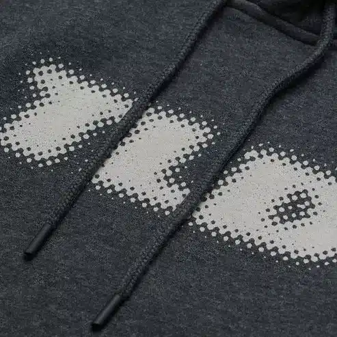 Detailfoto vom Frontprint und Kordelzug des Kapuzenpullovers Fade Out Schwarz Heather.