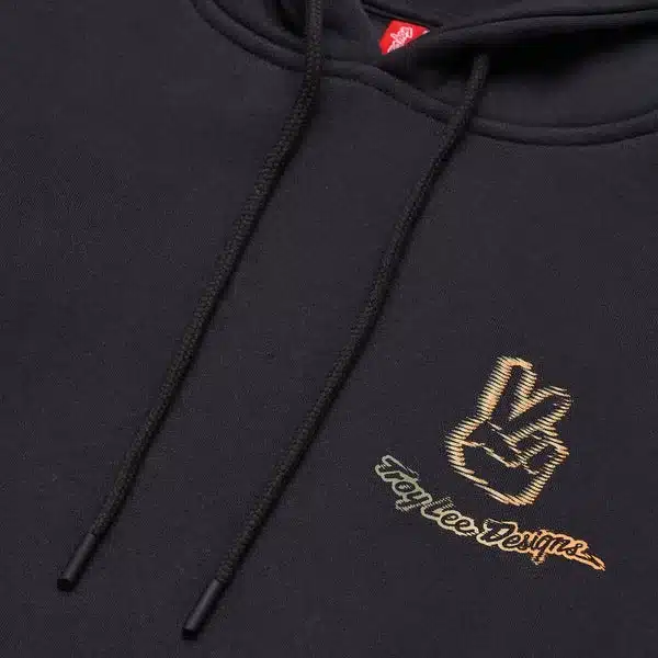 Detailaufnahme des TLD Pullover Hoodie Peace Out Carbon mit Peace-Handzeichen und Troy Lee Designs Logo.