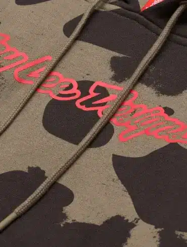 Detailfoto eines olivgrünen Camouflage-Kapuzenpullovers mit auffälligem Troy Lee Designs Schriftzug
