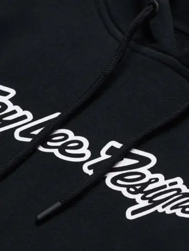 Schwarzer Troy Lee Designs Signature-Hoodie mit weißem Logo-Schriftzug, Detailansicht der Brustpartie.