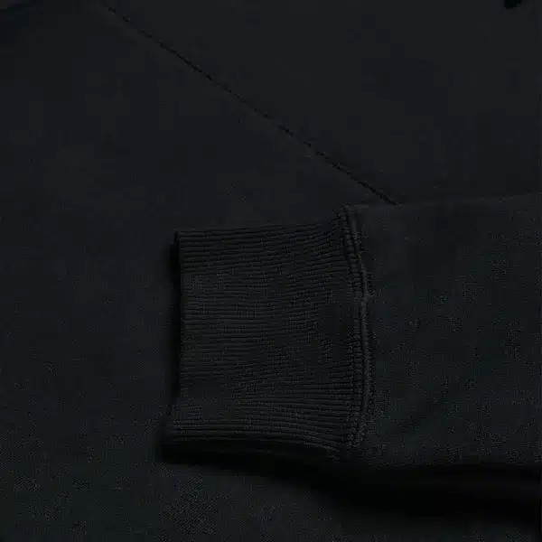 Detailaufnahme des Ärmelbündchens eines schwarzen Kapuzenpullovers Torched Black