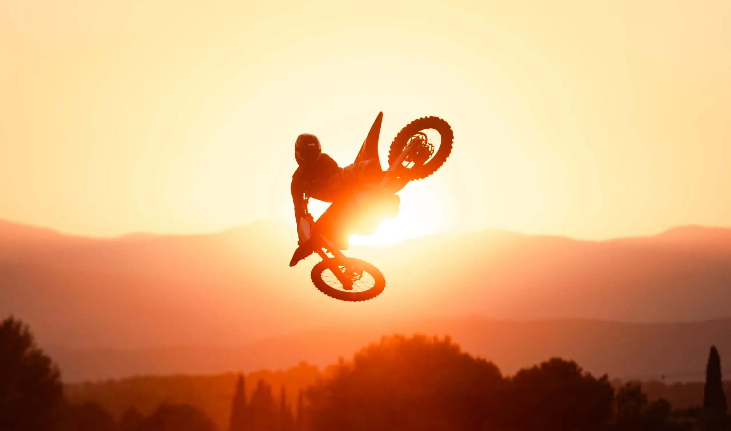 Stark VARG Elektromotorrad springt vor Sonnenuntergang durch die Luft