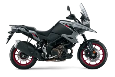 Seitenansicht der Suzuki V-Strom 1050 in Grau mit roten Felgen, prominent gezeigt vor weißem Hintergrund.