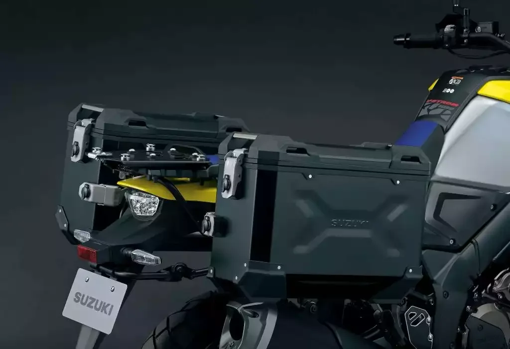 Seitenansicht der montierten Aluminium-Koffer an der Suzuki V-Strom 1050DE Travel Edition, gelb-silbernes Motorrad im Detail.