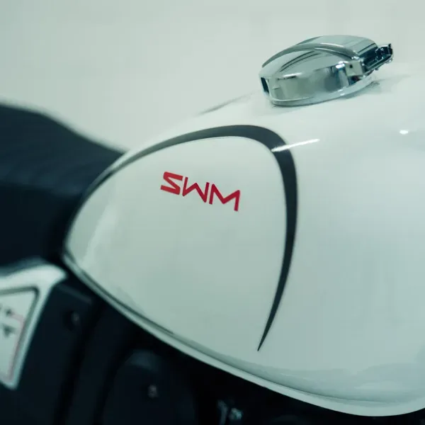 Nahaufnahme des weißen Tanks einer SWM Silver Vase T 650 mit SWM-Logo und Chrom-Tankdeckel.