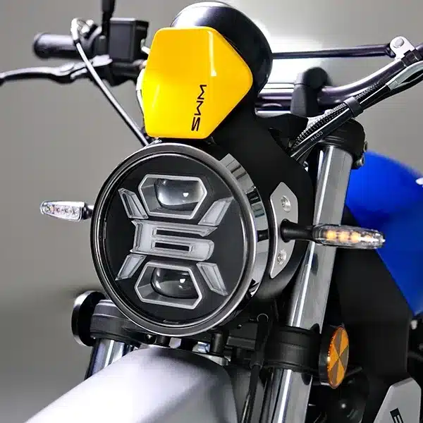Detailansicht des LED-Scheinwerfers und Cockpits einer SWM SIX6 650 Scrambler mit gelbem Windschild.