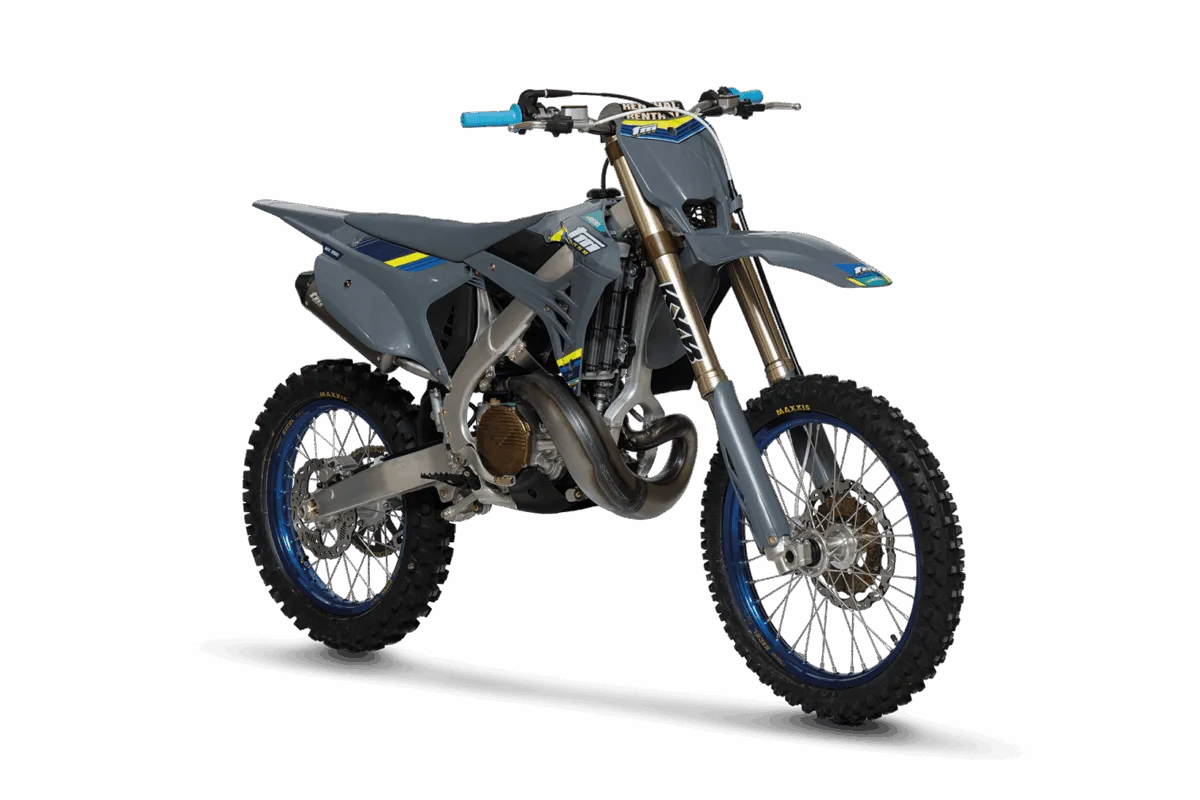 TM MX 250 ES 2T Corse 2026 Motocross-Motorrad in Grau mit blauen Felgen und gelben Akzenten, seitliche Frontansicht auf dunklem Hintergrund
