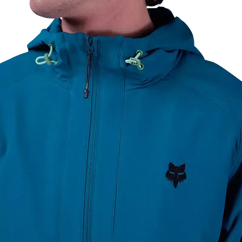 Nahaufnahme einer blauen Survivalist Windjacke mit anpassbarer Kapuze und Reißverschluss.