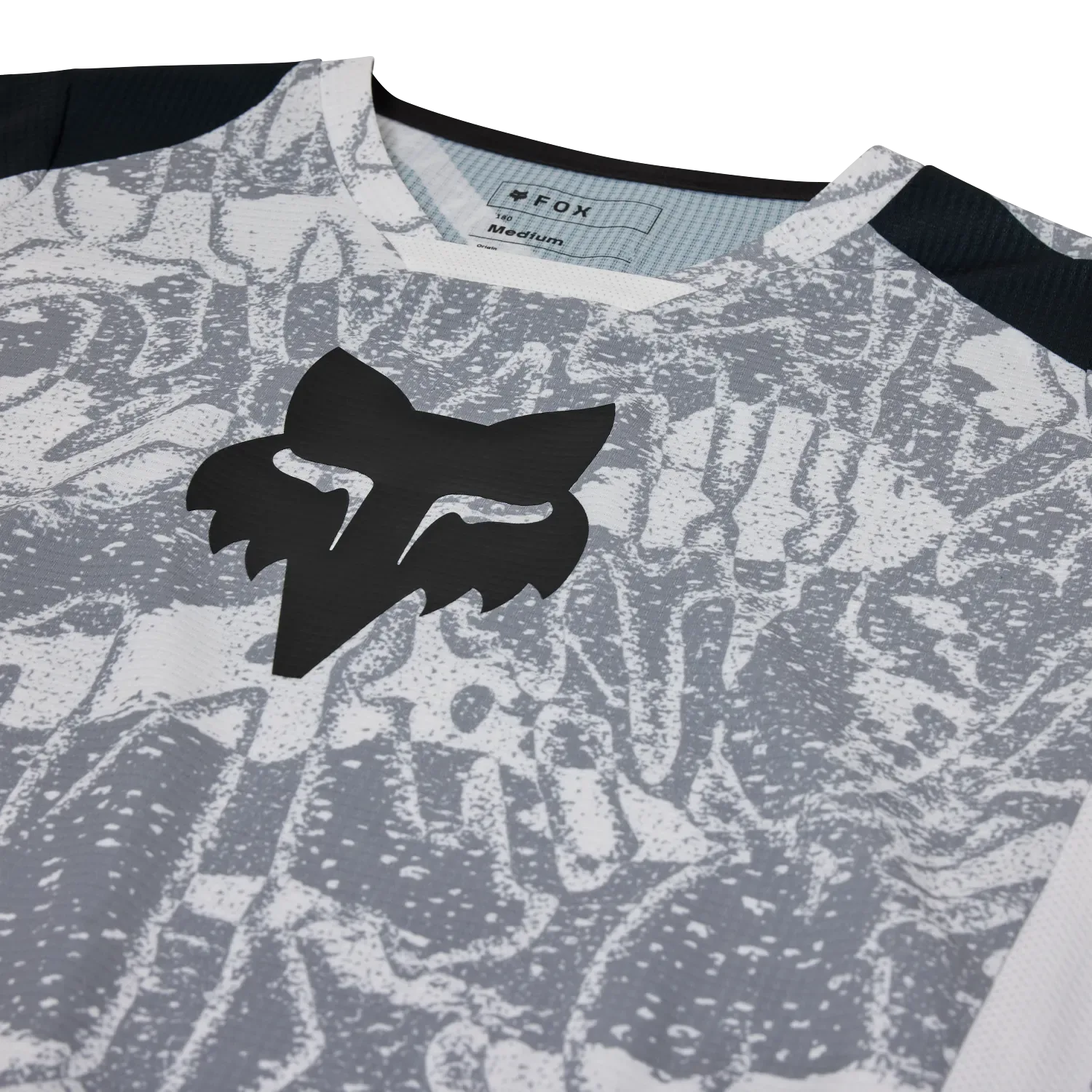 Nahaufnahme des FOX 180 DNGR Motocross-Trikots mit geprägtem Logo und strukturiertem Stoff