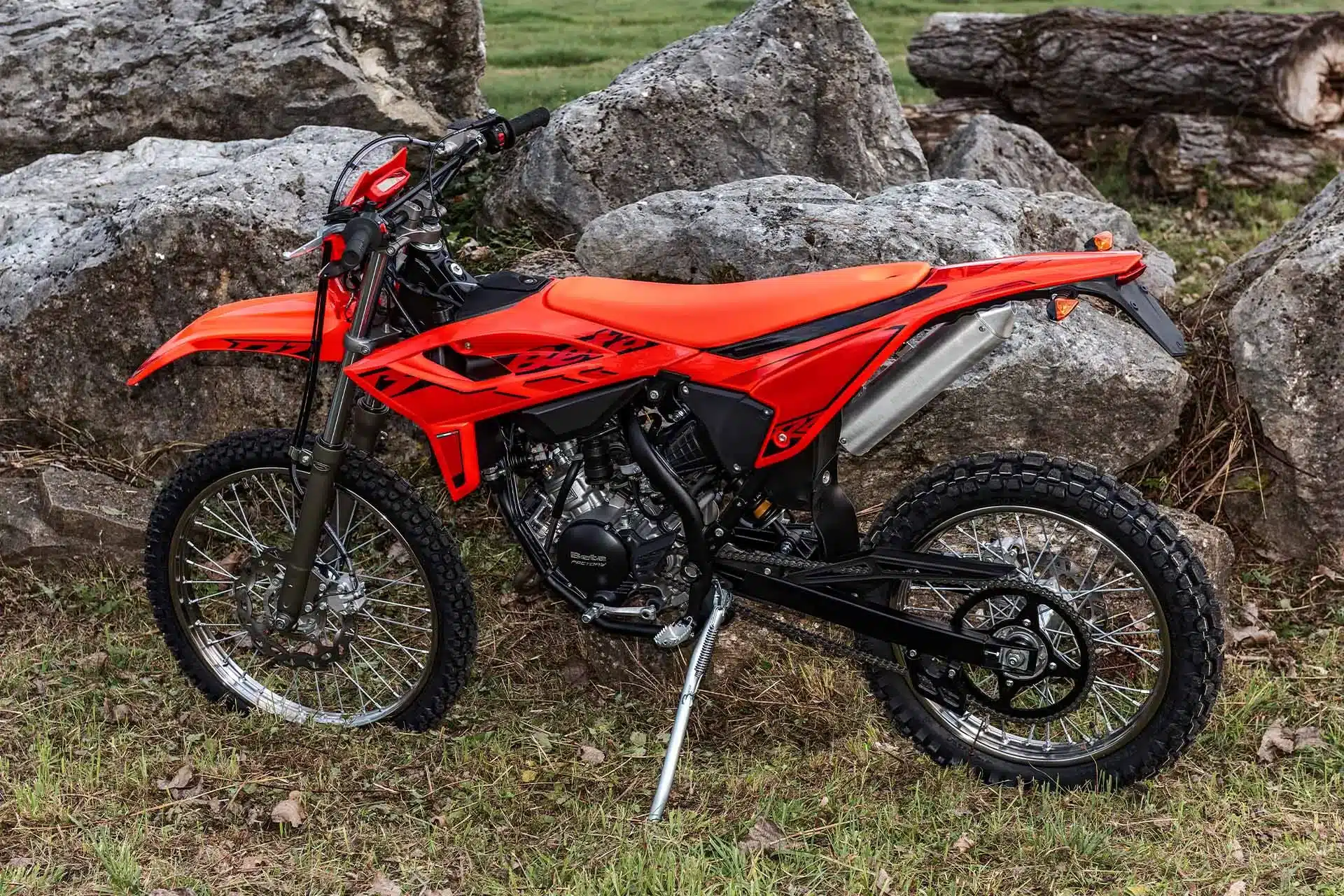 Beta RR 2T 50 Enduro 2025 in roter Lackierung im Gelände vor Felsen