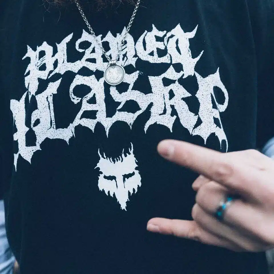 Brage Planet Alaska T‑Shirt mit markanter zentraler Grafik und Handgeste im Vordergrund