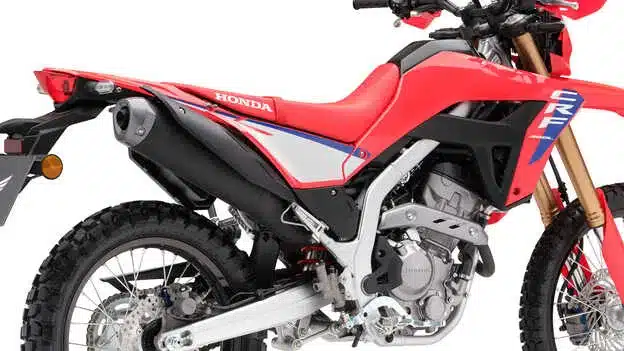 Nahaufnahme einer Honda CRF300L, Fokus auf Auspuff, Motor und Schwinge