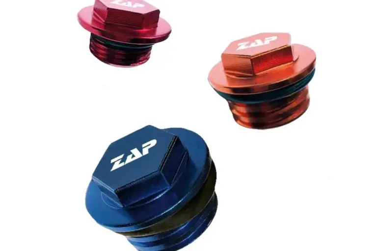 Drei Öleinfüllschrauben von ZAP in Rot, Orange und Blau auf weißem Hintergrund