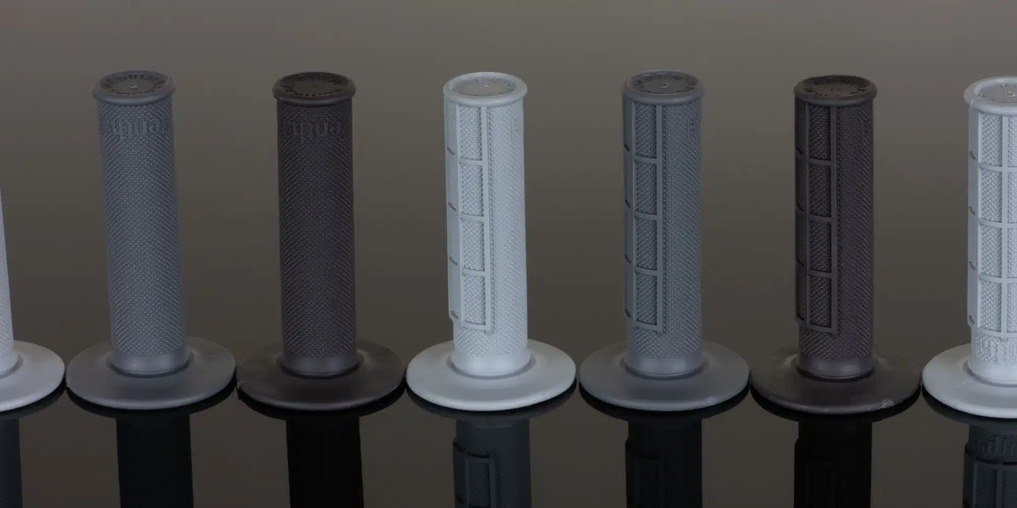 Verschiedene Renthal MX-Griffe in Serienanordnung, gezeigt in unterschiedlichen Profilen und Farben