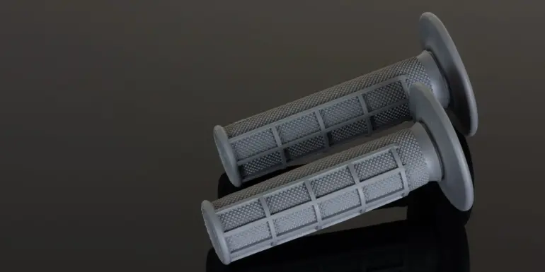 Zwei graue Renthal MX-Griffe im Full Waffle Muster auf dunklem Untergrund