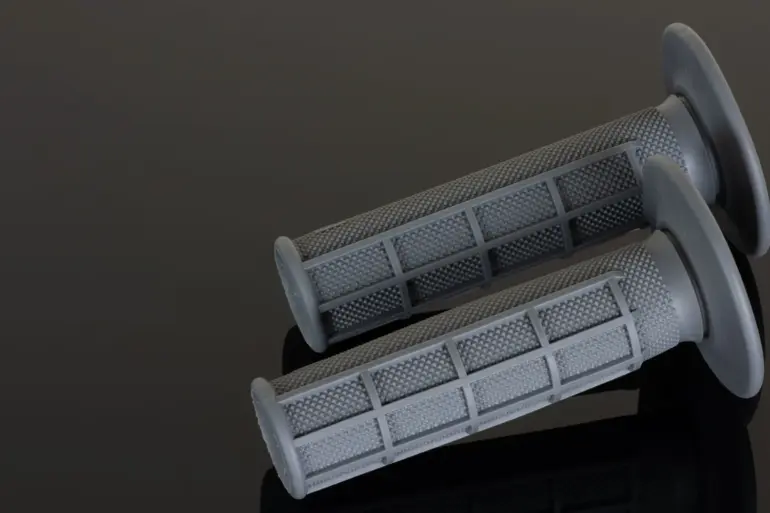 Zwei graue Renthal MX-Griffe im Full Waffle Muster auf dunklem Untergrund