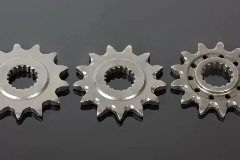 Drei Renthal Front-Kettenräder aus Stahl, nebeneinander auf schwarzer Oberfläche