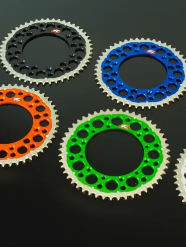 Renthal Twinring Kettenräder in Orange, Schwarz, Blau, Rot, Grün und Silber auf schwarzem Hintergrund