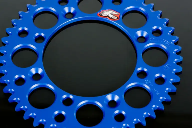 Blaues, leichtes Renthal-Kettenrad aus Aluminium mit Gewichtserleichterungsbohrungen und Mud-Groove-Design.