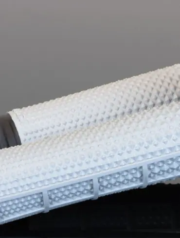 Weiße Tapered MX Griffe mit markanter Diamantstruktur und breitem Flansch auf spiegelndem Untergrund