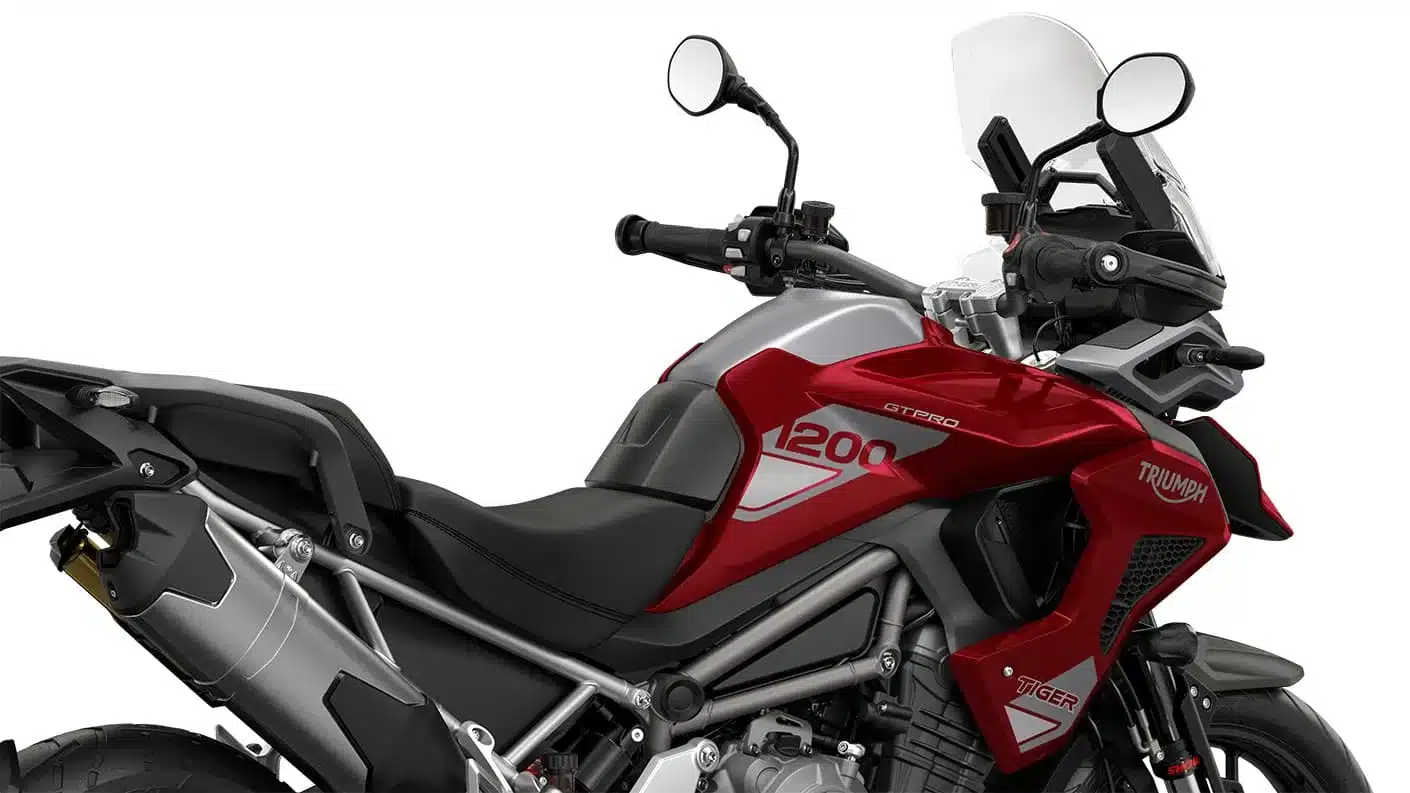 Triumph Tiger 1200 GT Pro Motorrad in Rot, Seitenansicht mit sichtbarem Tank, Lenker und Auspuff.