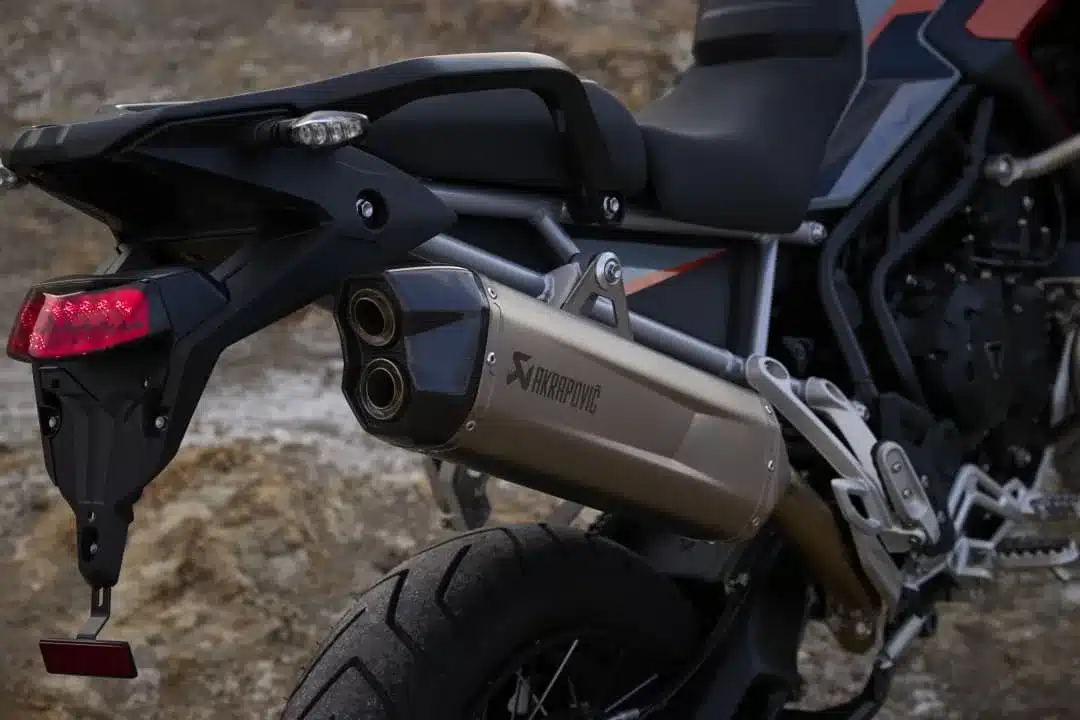 Auspuffanlage der Triumph Tiger 900 Desert Edition, Nahaufnahme mit Akrapovič-Schalldämpfer