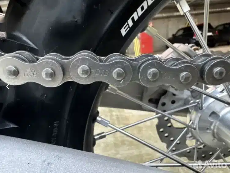 Detailansicht Antriebskette und Speichenrad einer Enduro mit grobstolligem Reifen