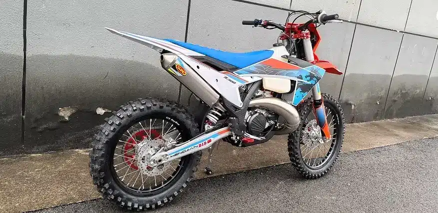 Hengjian S8 Z300 Enduro-Bike in seitlicher Ansicht, abgestellt vor einer grauen Wand auf nassem Asphalt