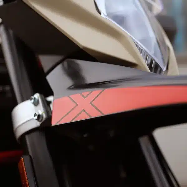 Detailansicht des vorderen Schutzblechs und Scheinwerfers der SWM Superdual X mit roter X-Grafik