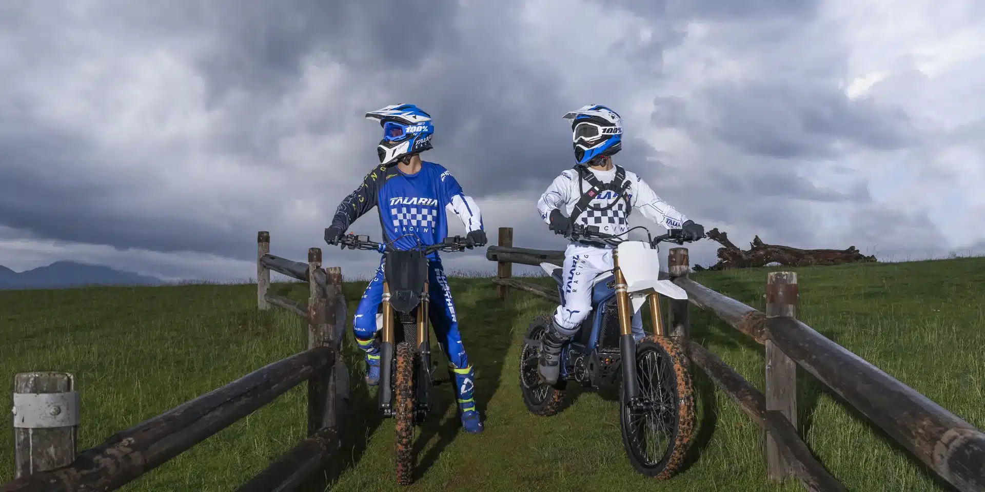 Zwei Talaria Komodo MX6 E-Offroad-Motorräder mit Fahrern in voller Ausrüstung im Gelände.