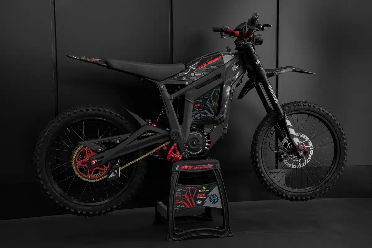 Elektrisches Offroad-Dirtbike Talaria Sting R MX4 Expert Edition in schwarzer Ausführung seitlich vor dunklem Hintergrund
