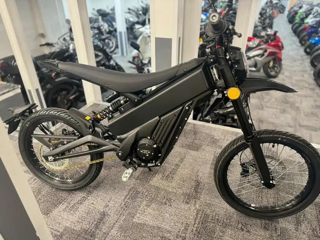 Talaria X3 L1E Elektro-Leichtenduro in schwarzer Ausführung, seitlich fotografiert, in einem Schauraum stehend.